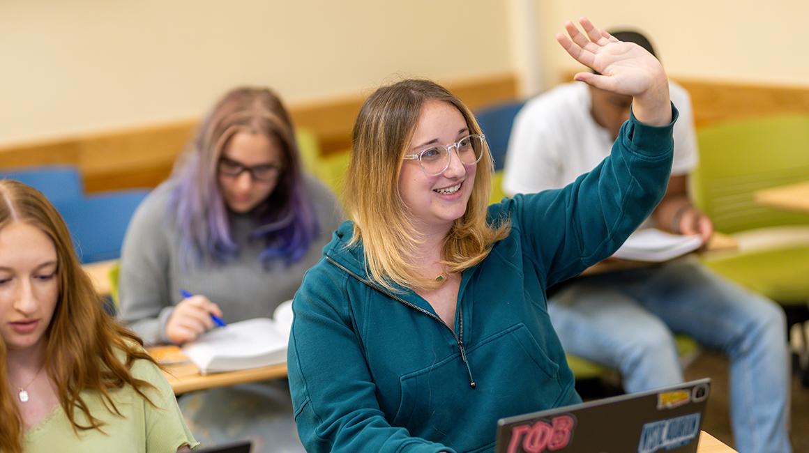 Kristen DeFlorio raises her hand during class in College Hall