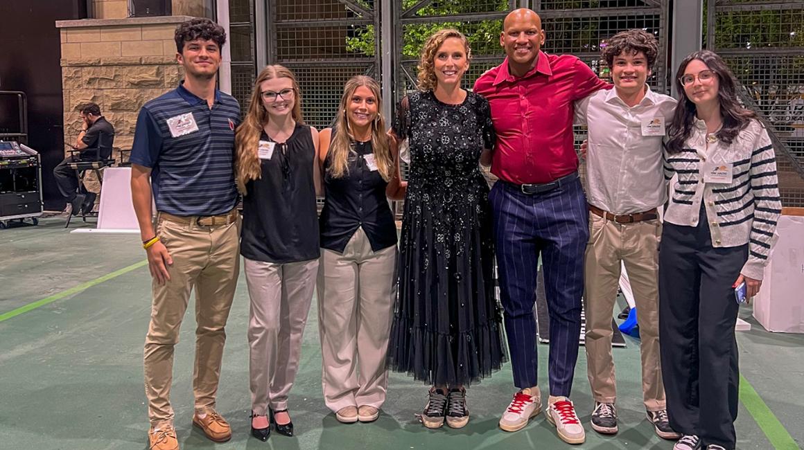 A group of Duquesne students stands with former Pittsburgh Steeler Ryan Shazier at his annual fundraising event at Acrisure Stadium.
