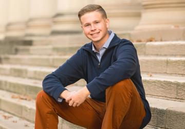 Xander Hill posing for a portrait on a staircase