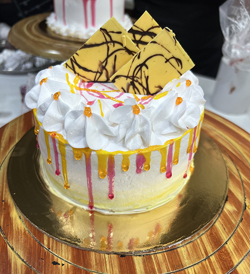 Yellow cake with pink and yellow decorations