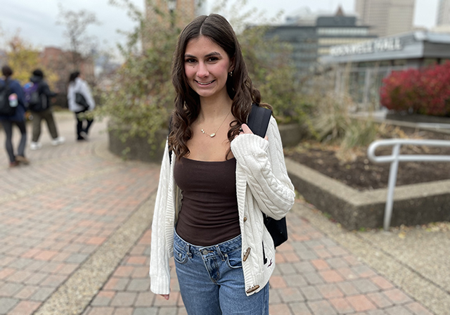 Business student Kate Turner stands with her backpack outside of Rockwell Hall.