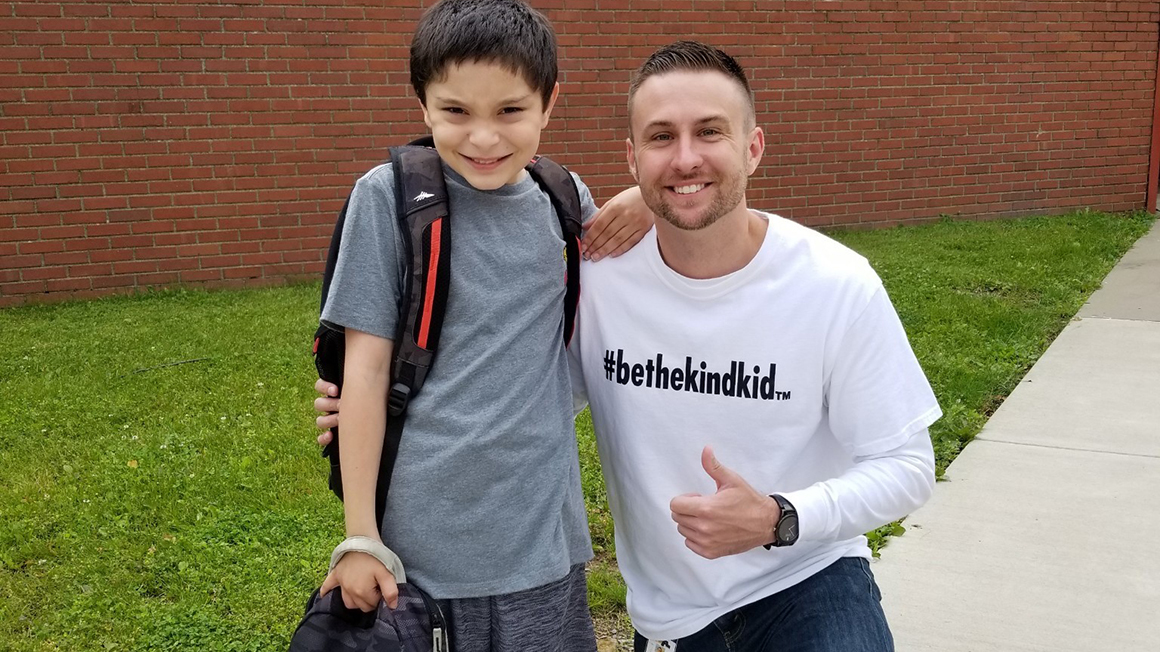 Principal Matt Hickman stands outside with a student