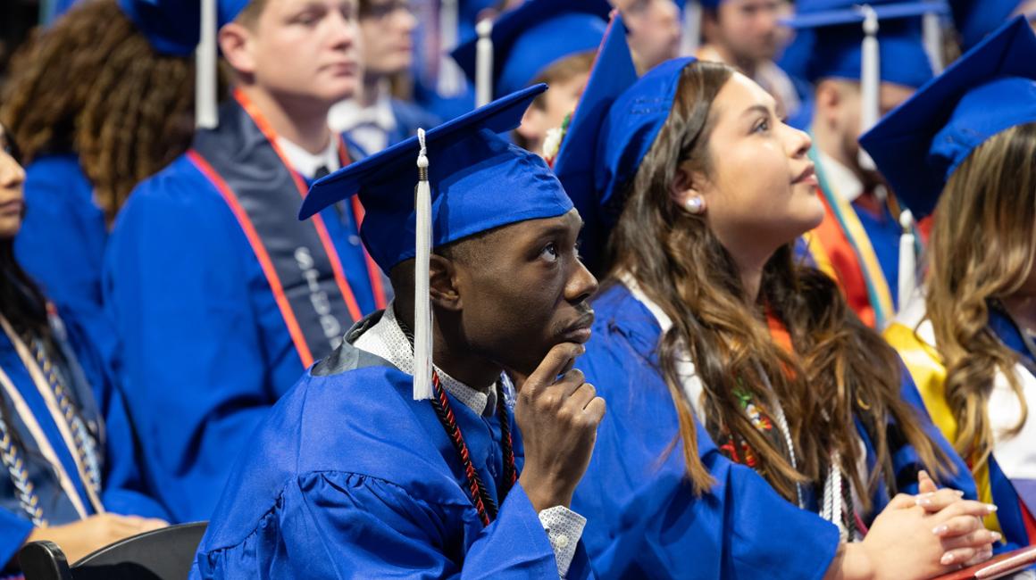 Graduate with his hand on his chin