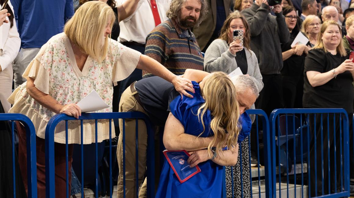 Dad hugging daughter in graduation robe