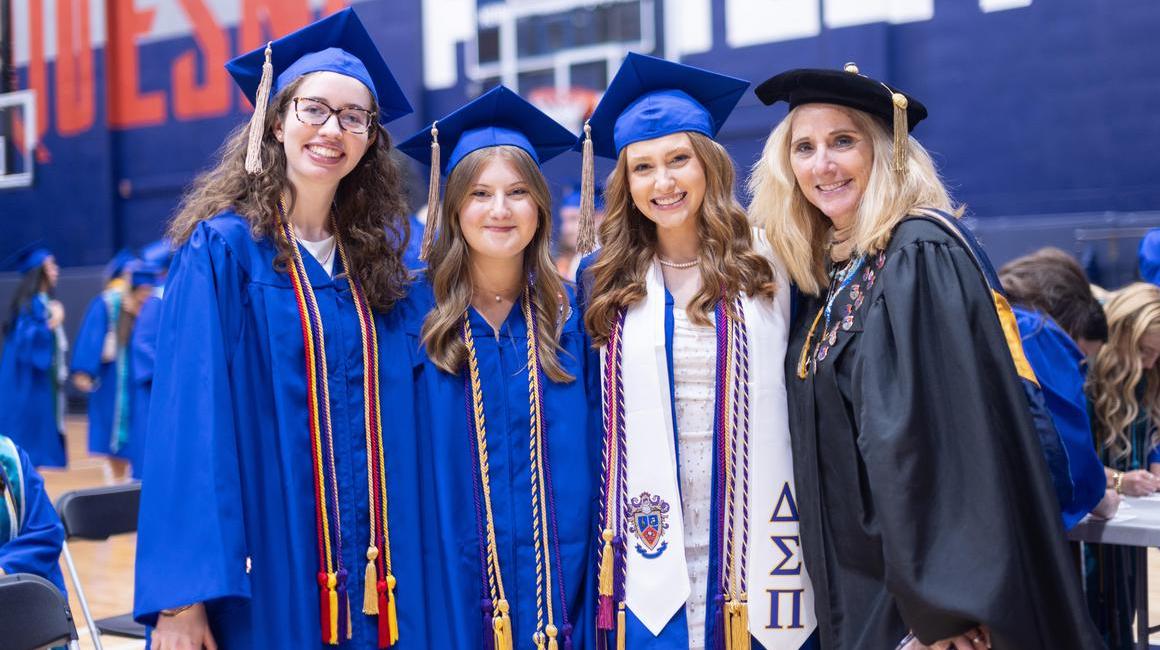 Three Female Graduates and Faculty Member