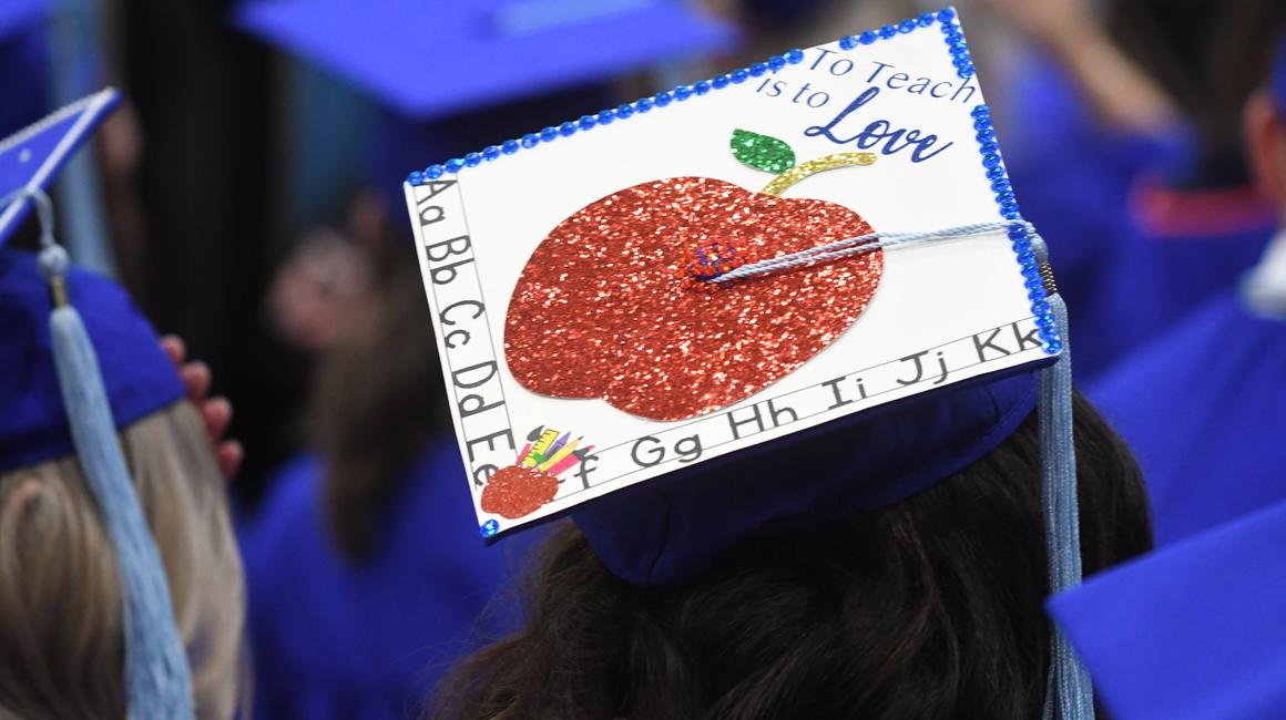 Graduation cap with apple and artwork on it