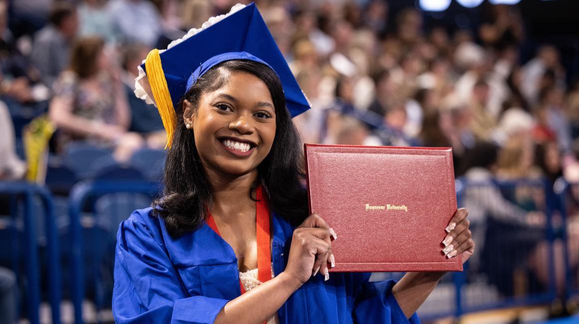 Graduate holding her diploma folder