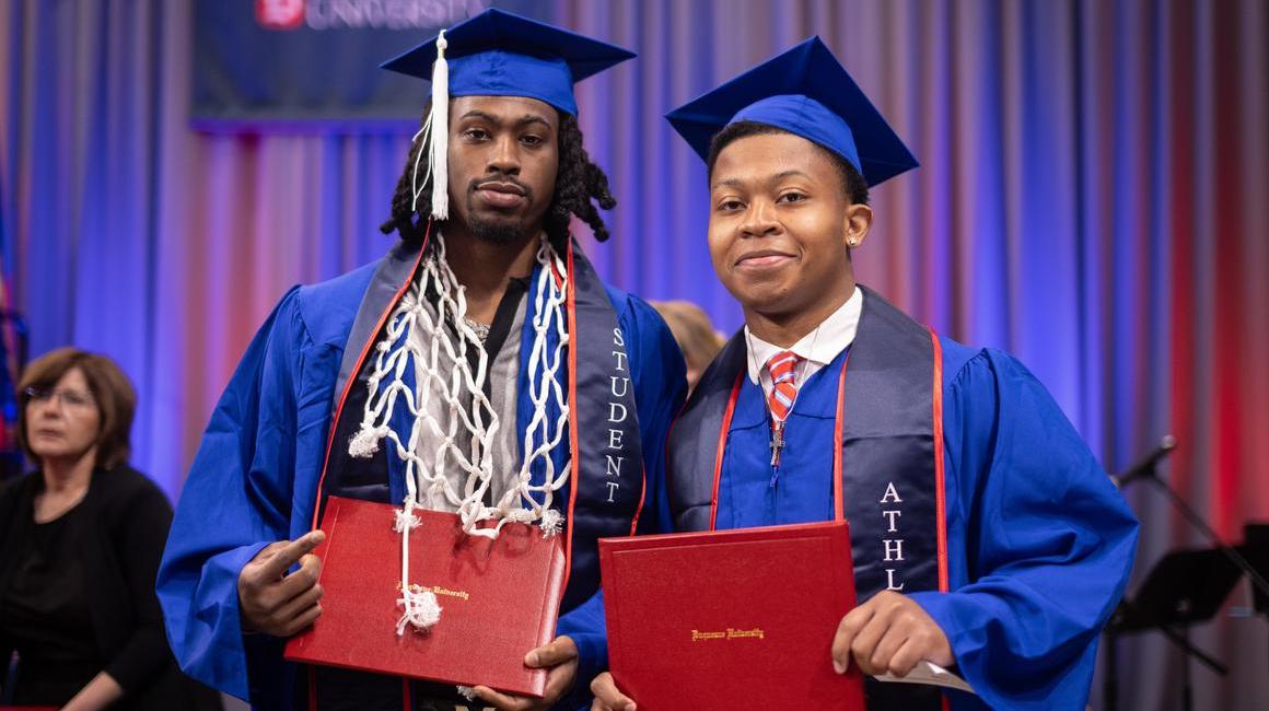 Two graduates with diplomas