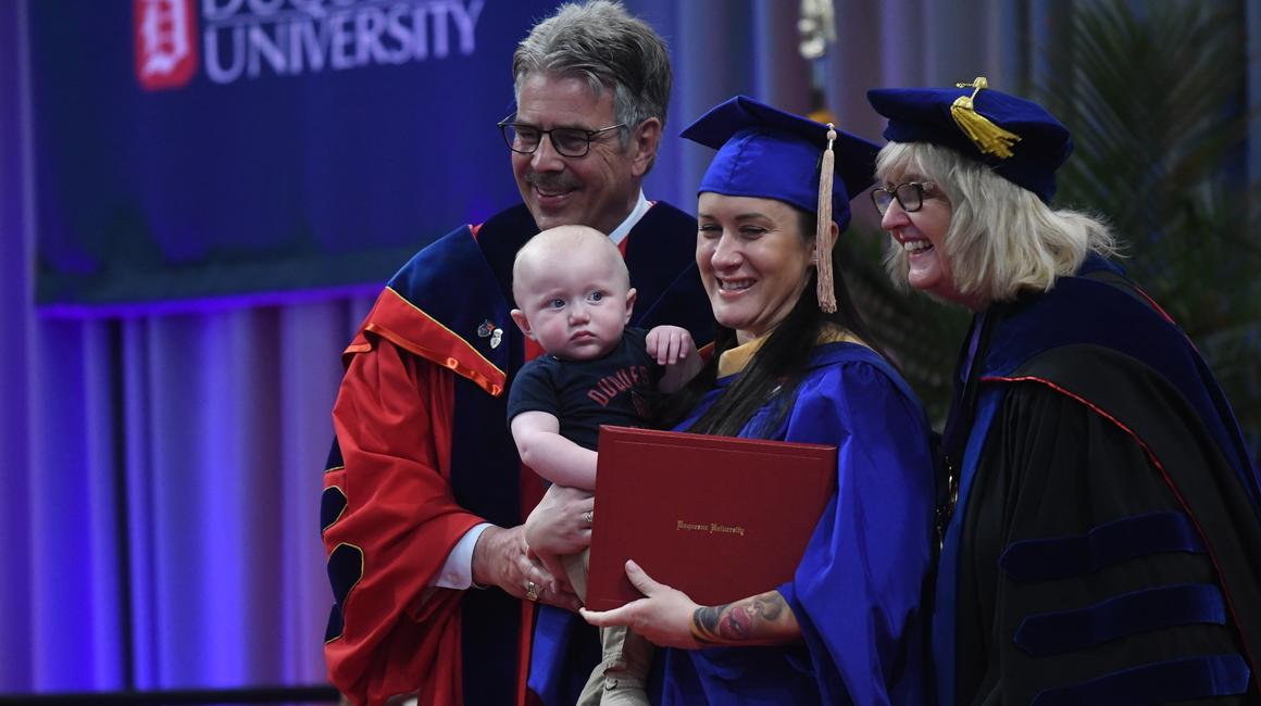 President Gormley with graduate holding a baby
