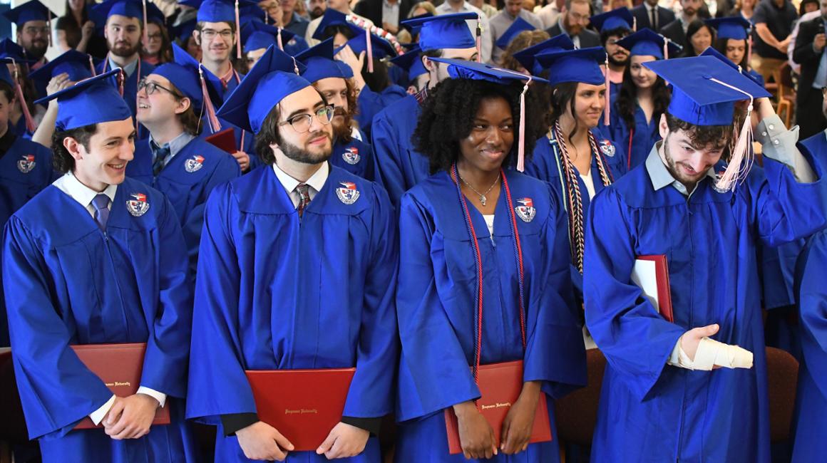 Music school graduates standing in caps and gowns
