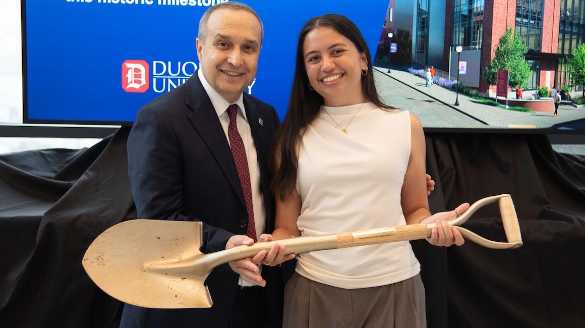 Dean Akinci holding shovel with student