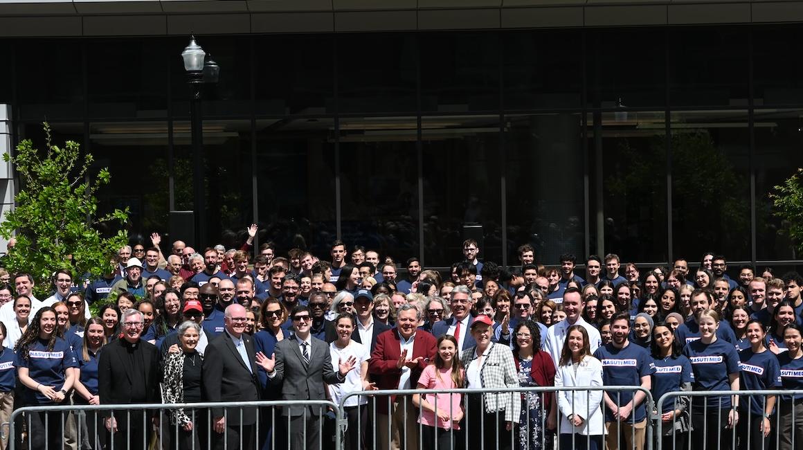 Faculty, staff and students pose outside the building 