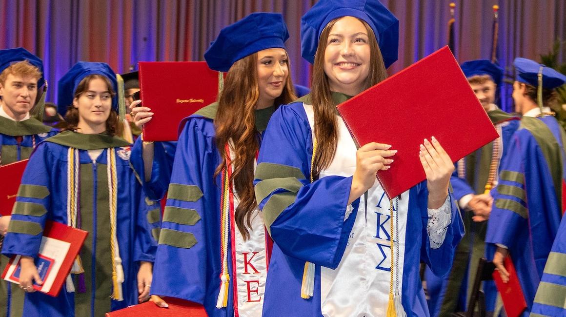 Pharmacy graduates smiling with their diplomas