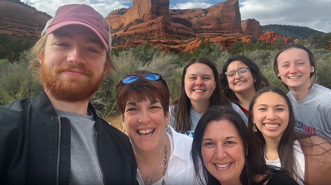 Students taking a selfie in New Mexico, mountains in the background.