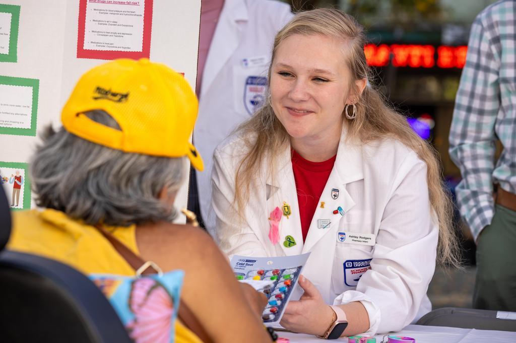 Duquesne pharmacy student assists a community member at a health fair