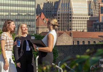 Students outside on campus with city behind them