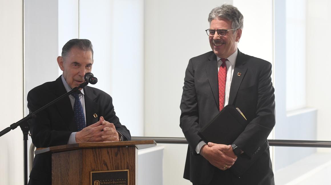 Eugene Beard presents at a podium alongside President Ken Gormley