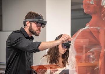 Students studying hologram of human body