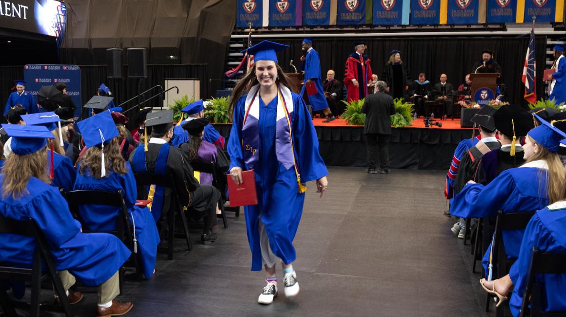 Student holding diploma at graduation ceremony