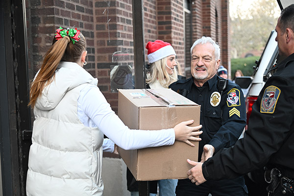 School of Education student and Duquesne University Police Sergeant Frank Cortazzo loads holiday gifts for transport