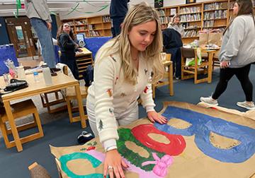 Zoe Brunick paints holiday sign