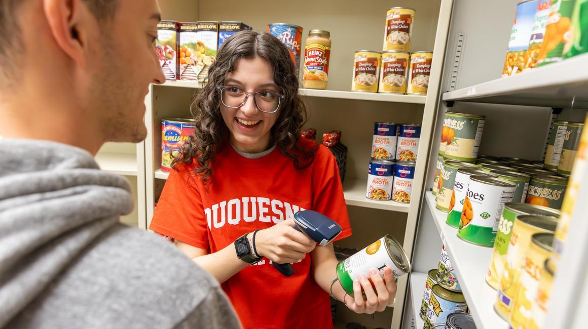 A student worker scans a canned good in the McAnulty Keating Pantry.