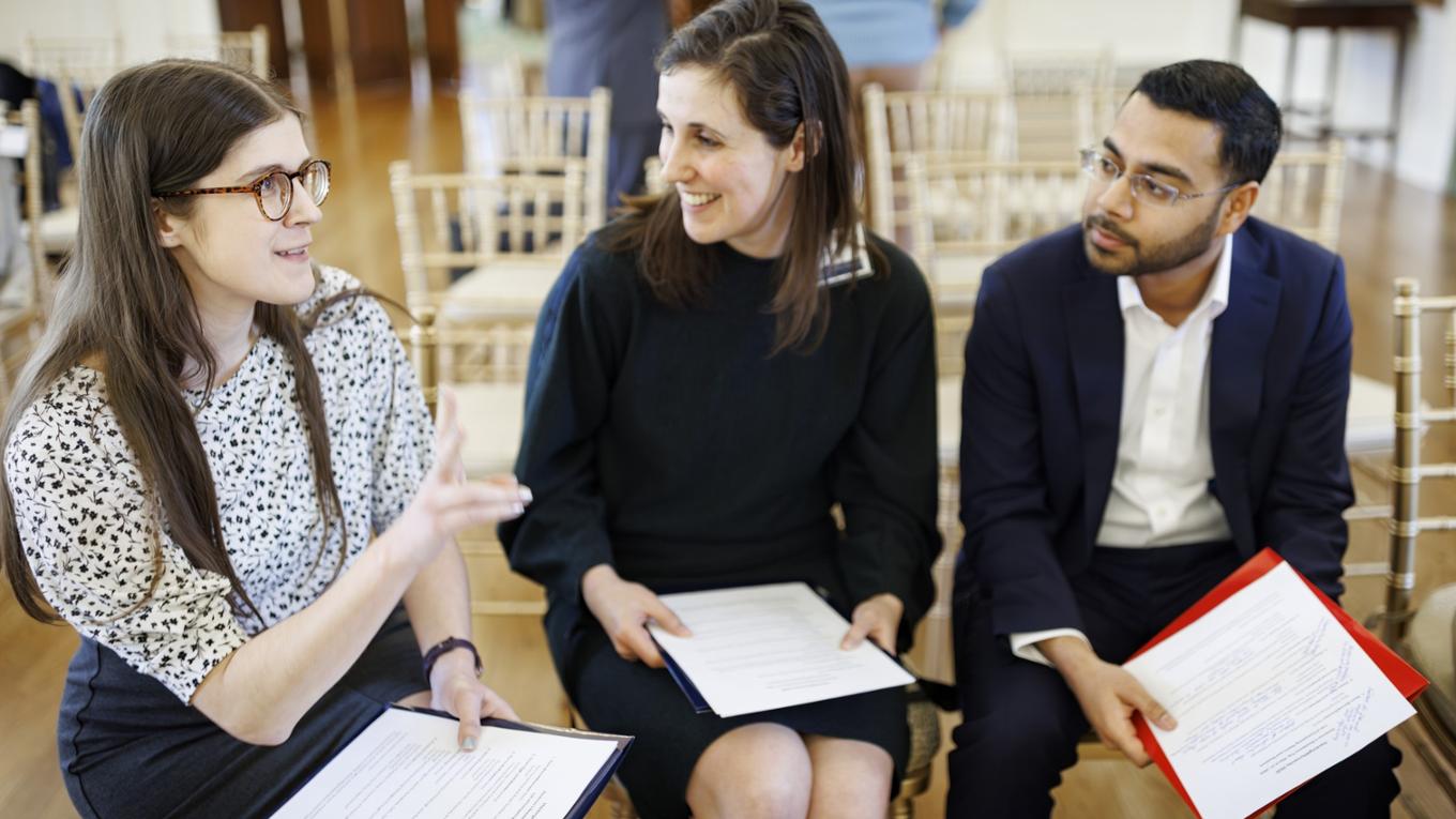 three individuals sit in chairs discussing hackathon presentations at the governor's residence in 2025