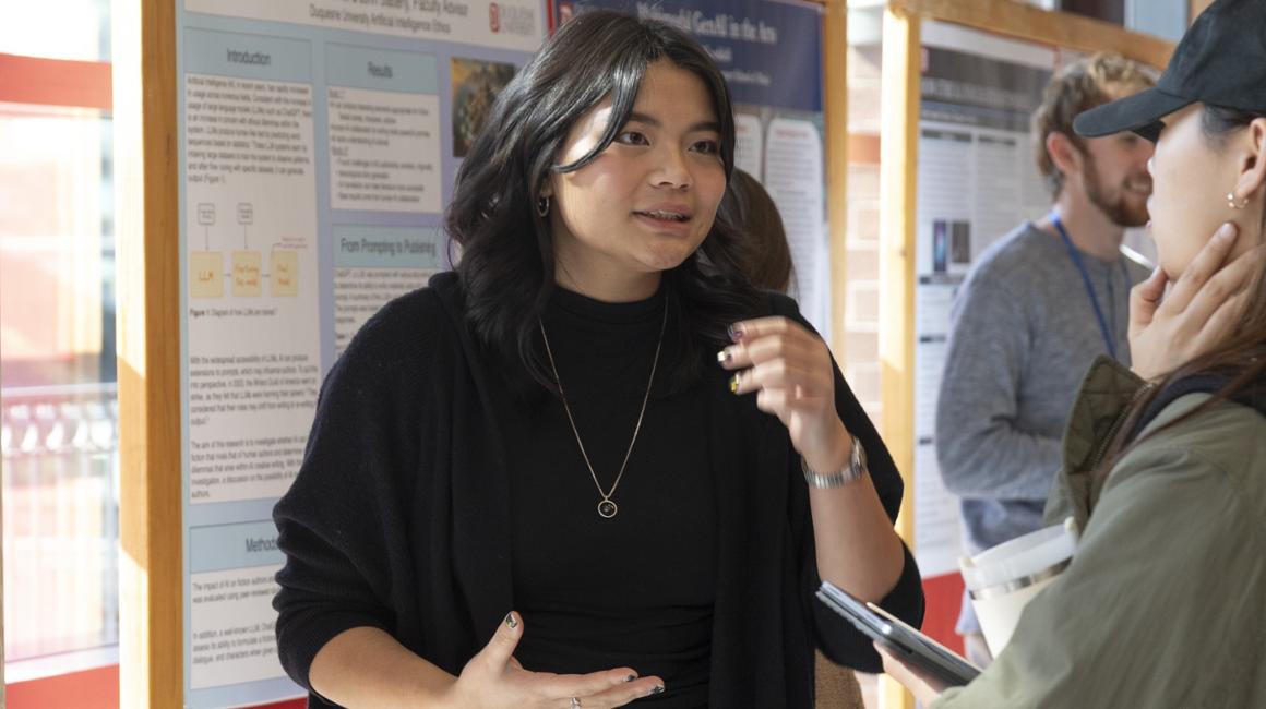 Student presenter discusses poster with 2024 Tech Ethics Symposium attendee