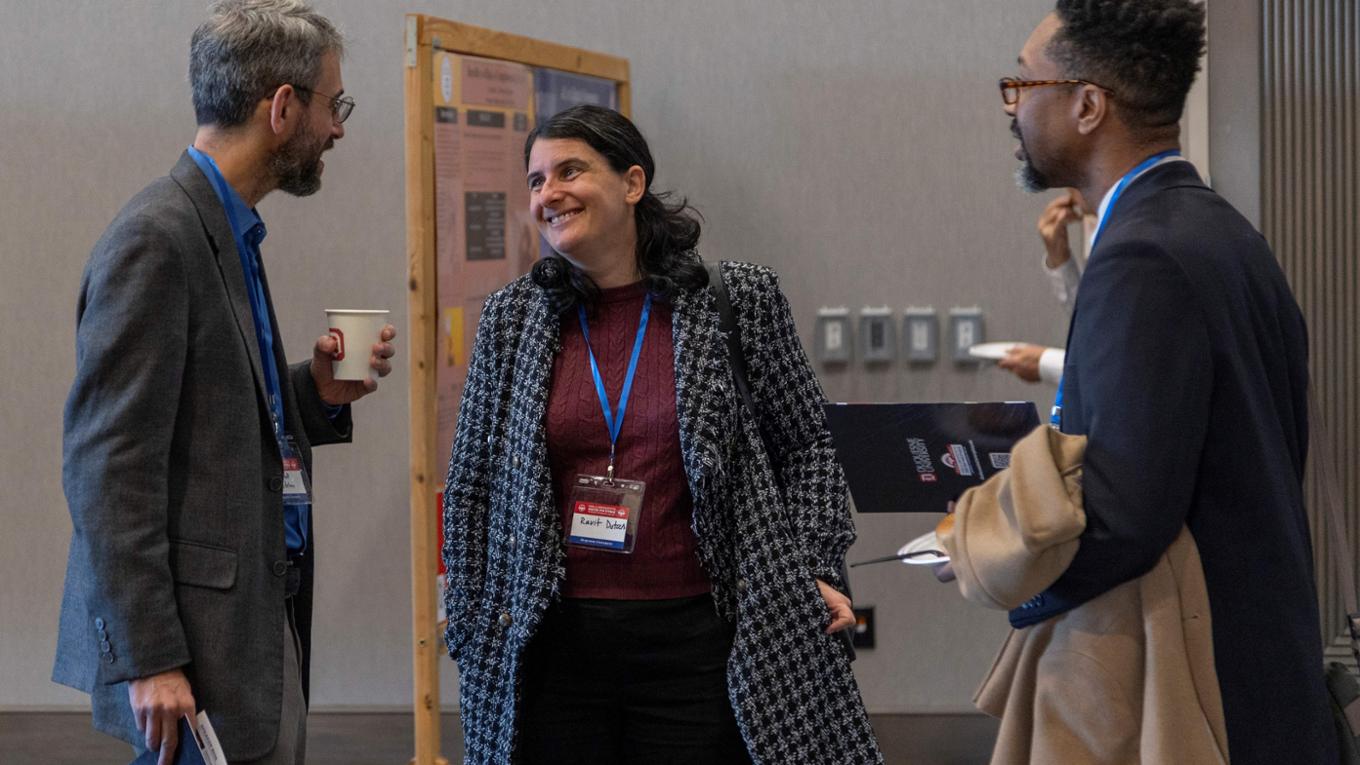 A group of three presenters and attendees chat at the 2024 Tech Ethics Symposium