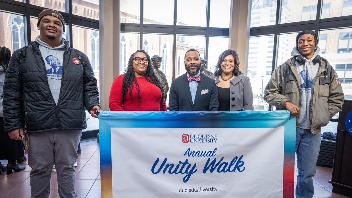 Student and staff holding the Annual Unity Walk banner