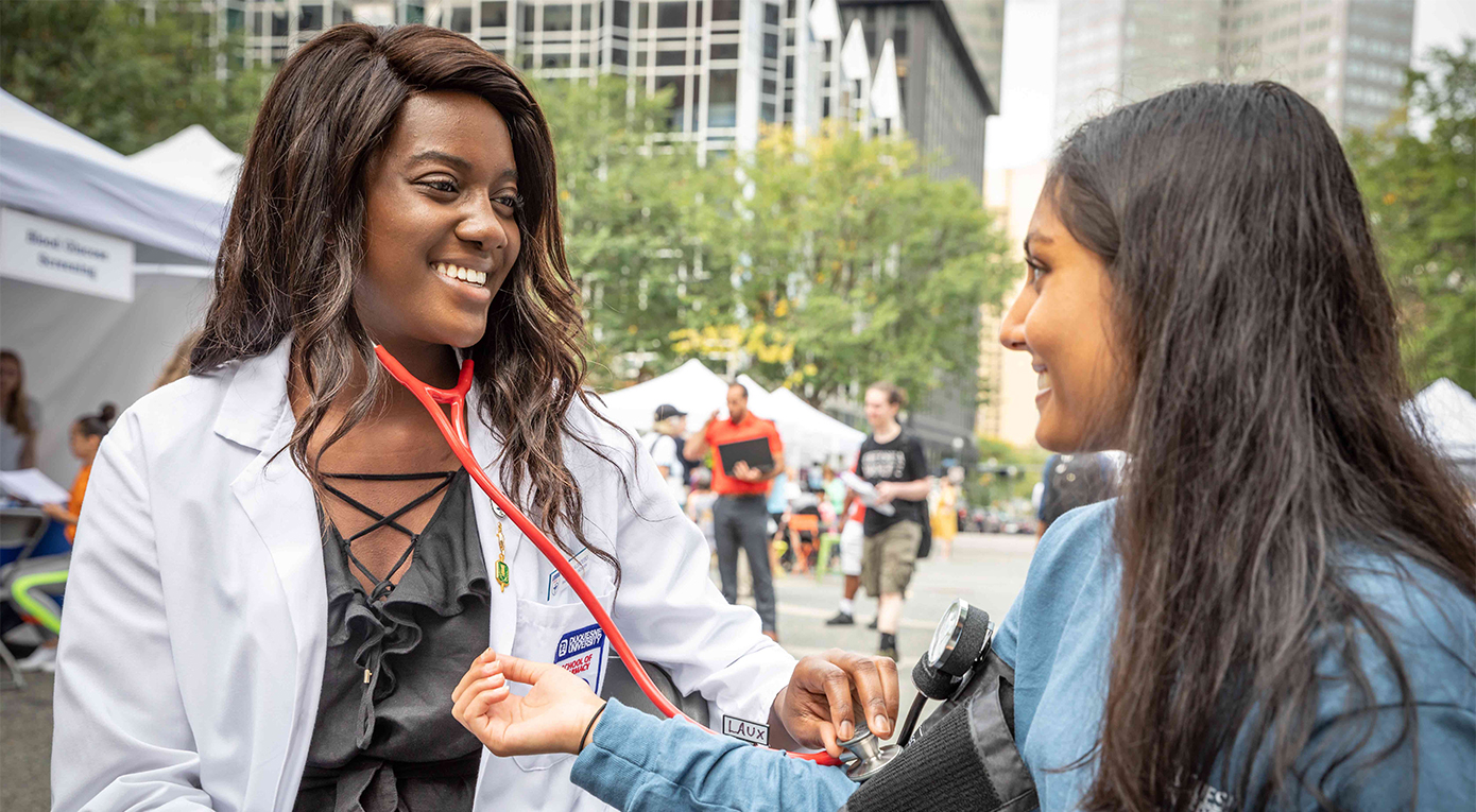 Pharmacy student taking blood pressure of community member.