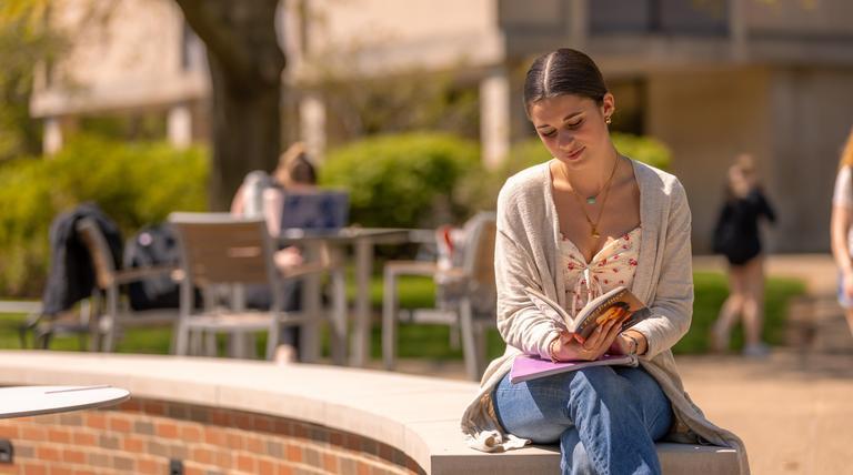 Student reading on campus. 