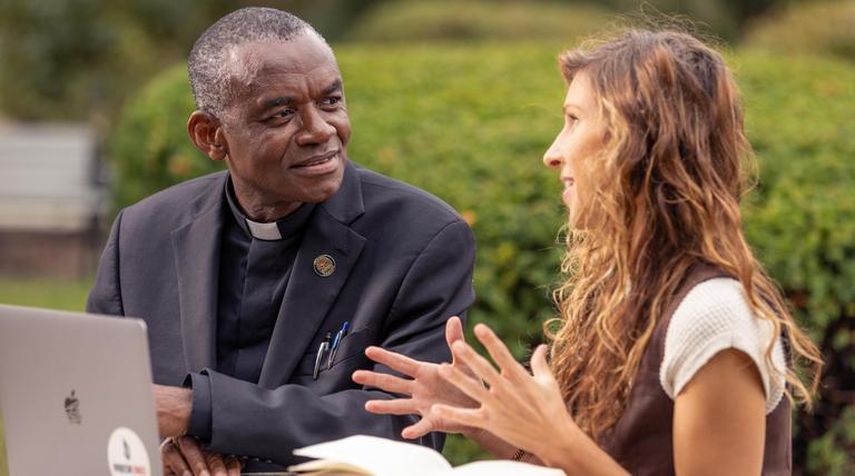 Spiritan priest working with a graduate student. 